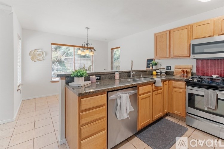 A kitchen with wooden cabinets and a granite countertop.