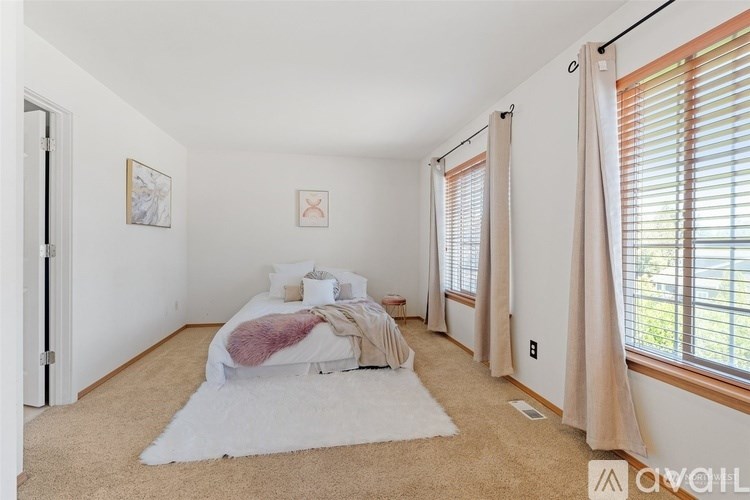 A bedroom with a bed, pillows, and a blanket.