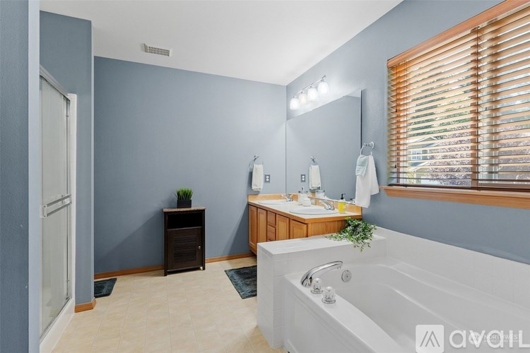 A bathroom with a white bathtub and a wooden vanity.