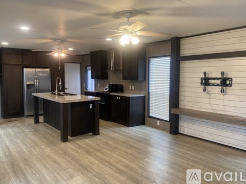 A modern kitchen with dark wood cabinets and a central island.