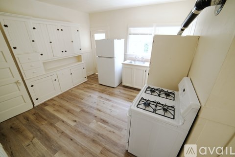 A kitchen with a white gas stove and wooden floors.