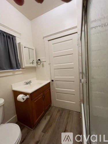 A small bathroom with a toilet, sink, and mirror.