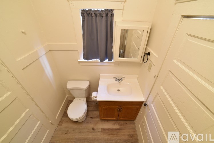 A small bathroom with a toilet, sink and window.