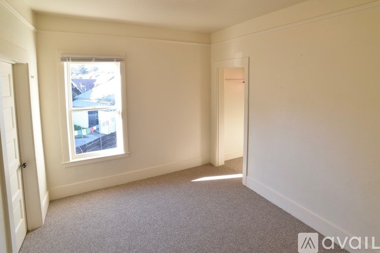 A room with a window and a door is available for rent.