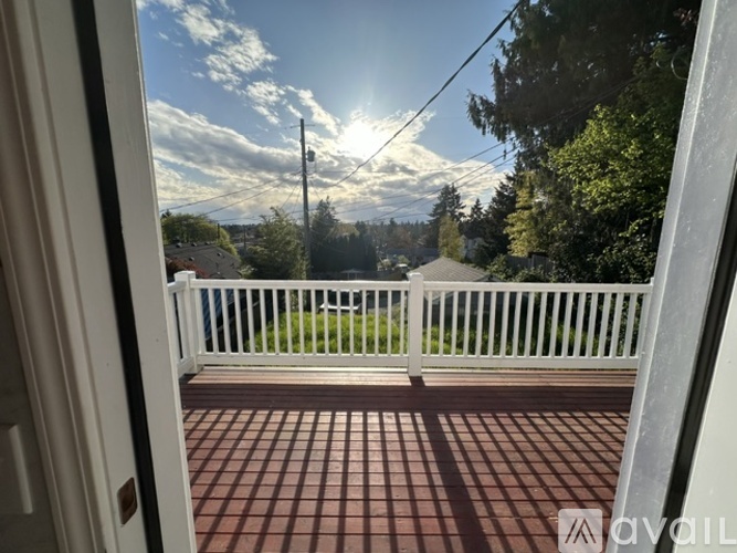A view from a doorway looking out to a white fence and a telephone pole.