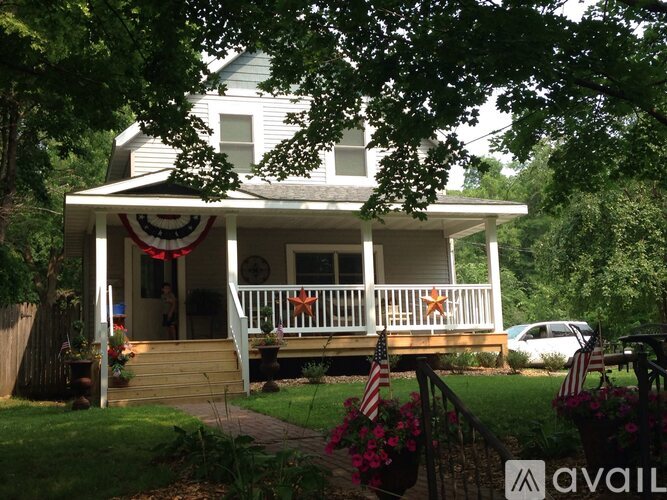 A house with a porch and a flag hanging on the wall.