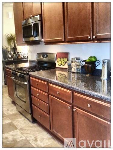 A kitchen with brown cabinets and a black countertop.