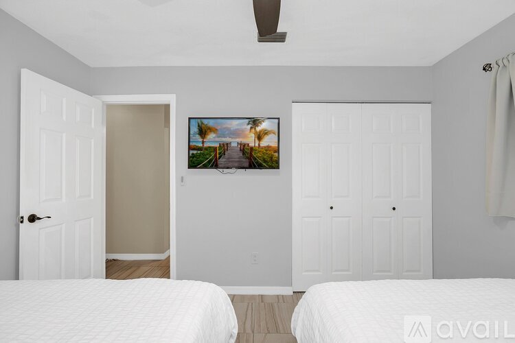 A bedroom with two beds and a painting on the wall.
