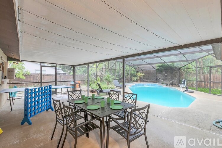 A patio with a table and chairs and a pool.