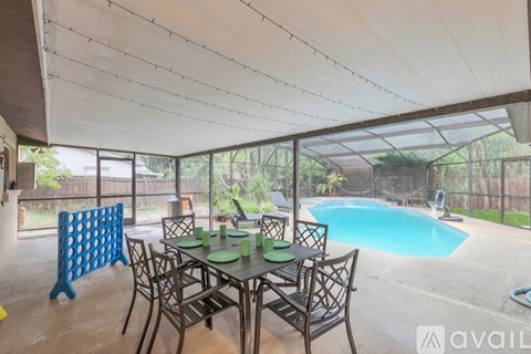 A patio with a table and chairs and a pool.