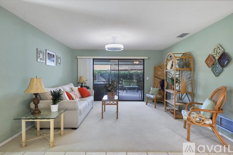 A living room with a grey couch, a coffee table, and a lamp.