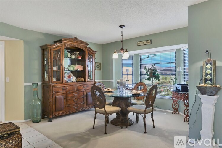 A dining room with a wooden table and chairs.
