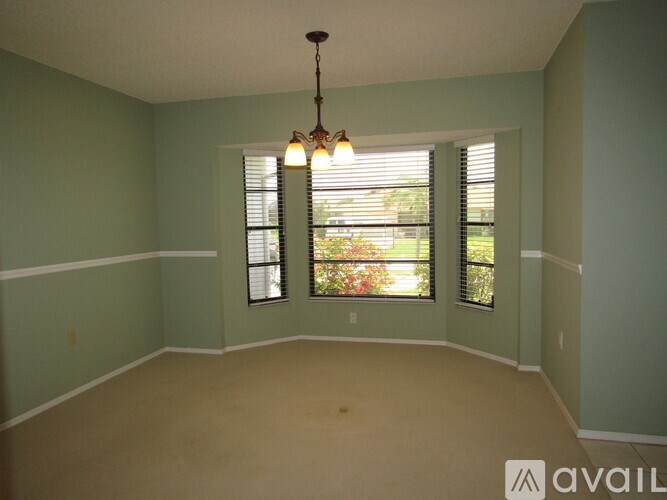 A room with a chandelier and two windows.