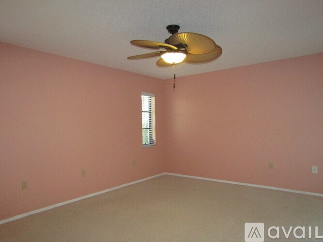 A room with a ceiling fan and a window.