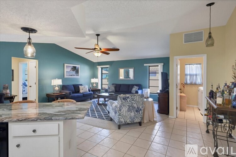A living room with a blue couch and a fan.