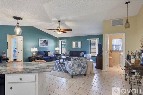 A living room with a blue couch and a fan.