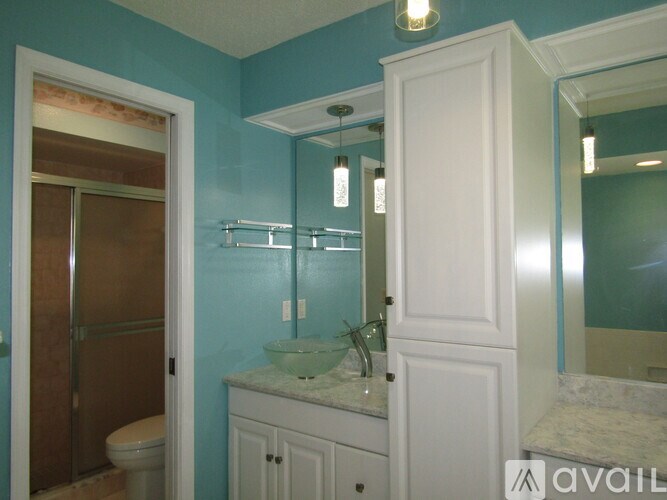 A bathroom with a toilet, sink, and mirror.