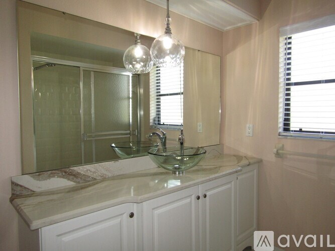 A bathroom with a marble countertop and a large mirror.