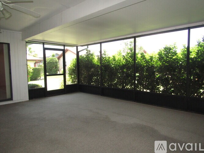 A room with a carpet floor and a ceiling fan.