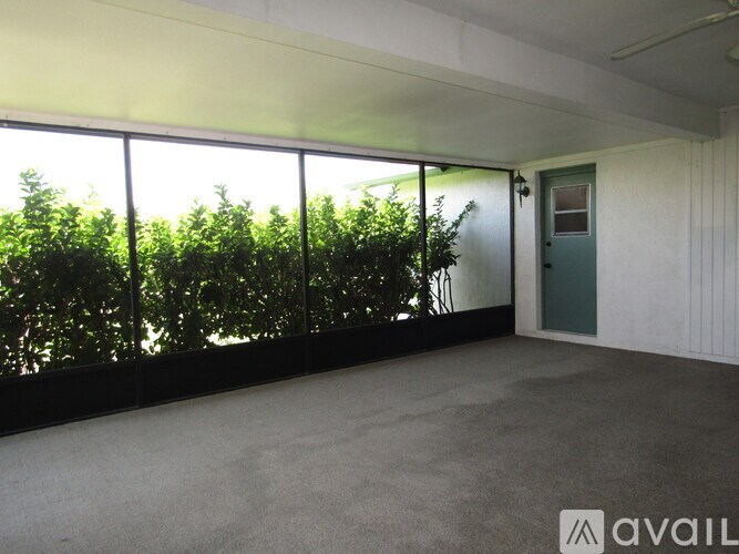 A room with a large window overlooking a green area.