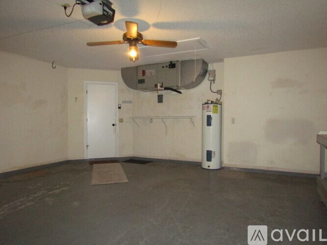 A room with a ceiling fan and a white door.