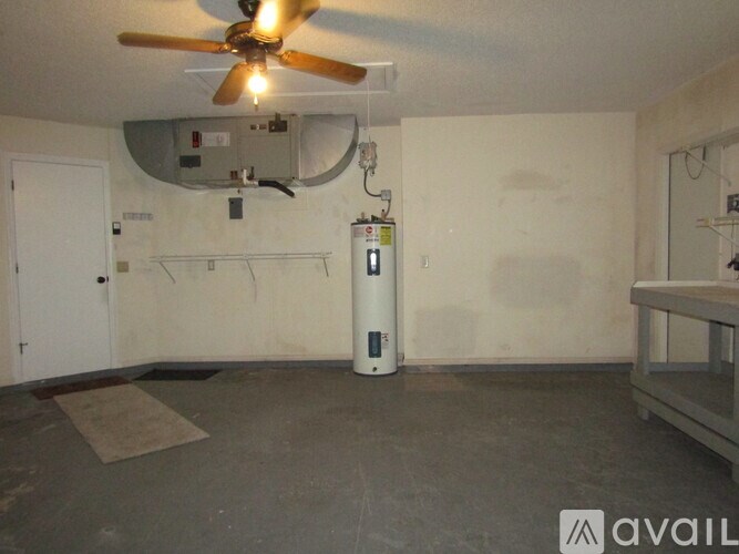 A room with a ceiling fan and a white door.