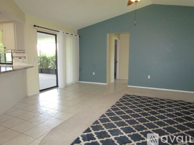 A room with a rug on the floor and a door on the right side.