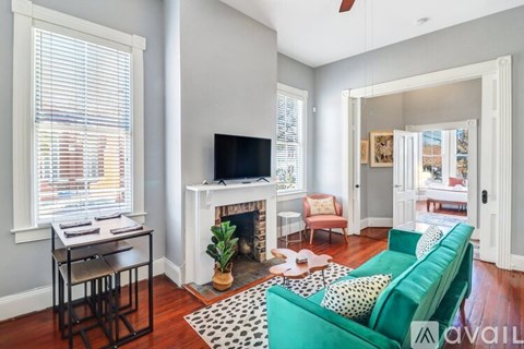 A living room with a green couch and a fireplace.