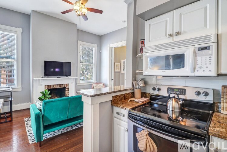A kitchen with a black stove top oven and a white microwave above it.
