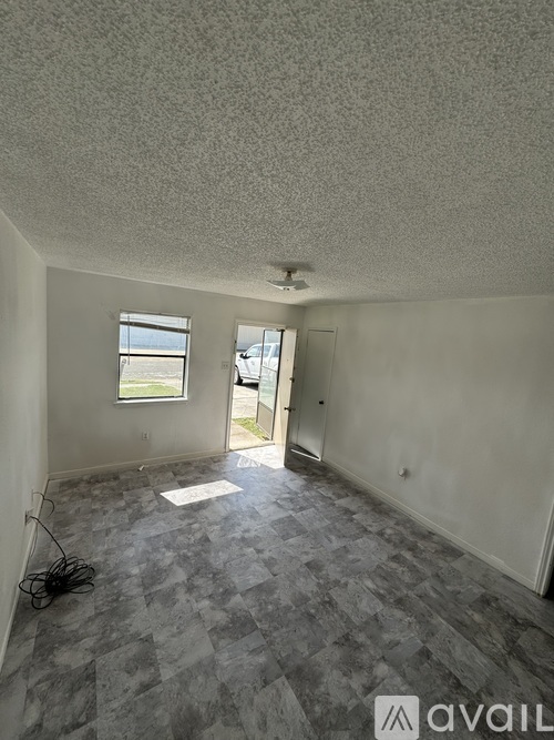 A room with a checkered floor and a door leading to a balcony.