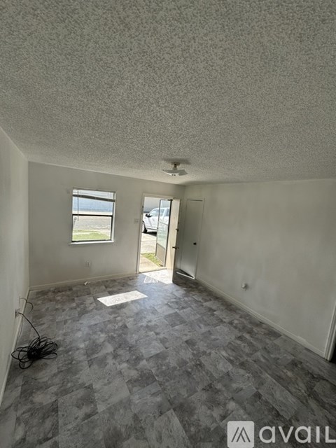 A room with a checkered floor and a door leading to a balcony.
