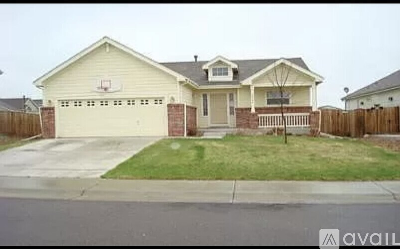 A house with a garage and a basketball hoop on the wall.