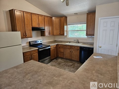 A kitchen with brown cabinets and a white refrigerator.