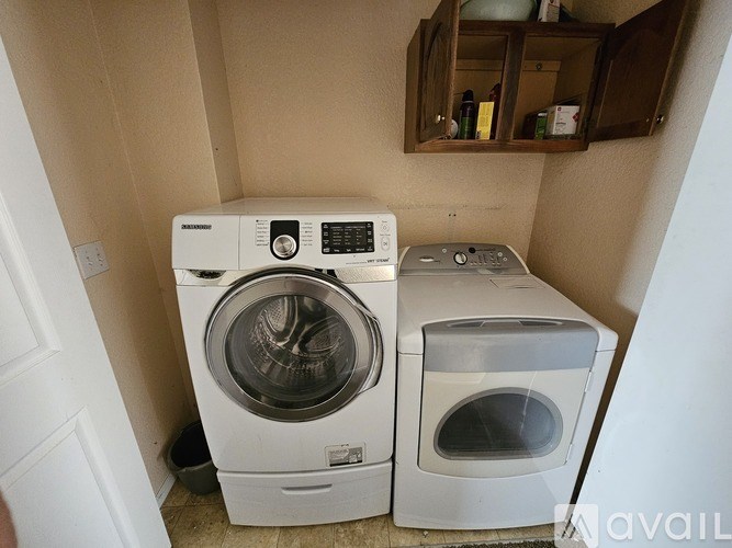 A white washing machine and dryer in a small laundry room.