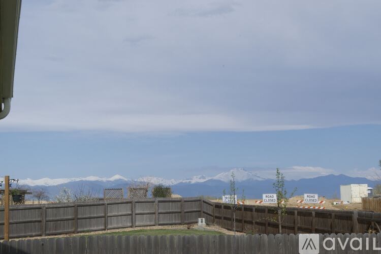 A view of a fenced area with a mountain range in the distance.