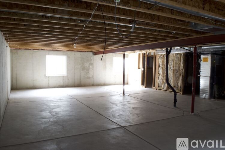 A large empty room with a concrete floor and walls under construction.