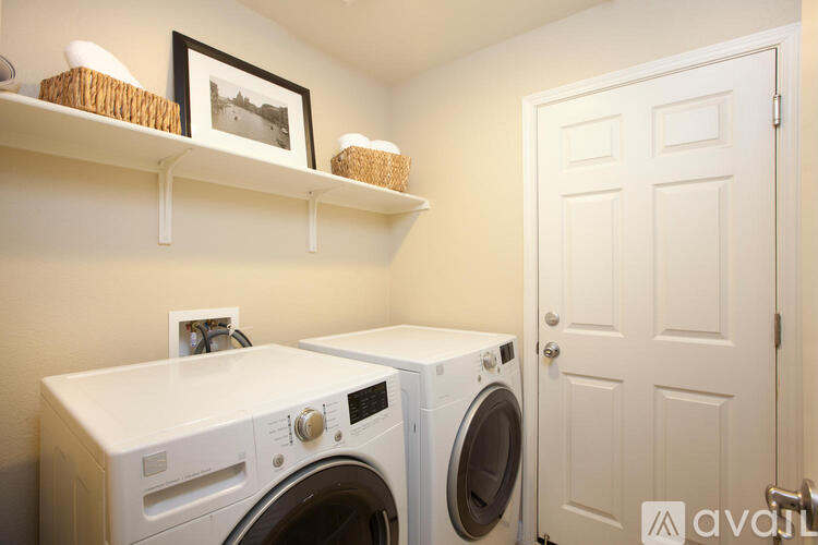 A white door is in a laundry room with a washer and dryer.