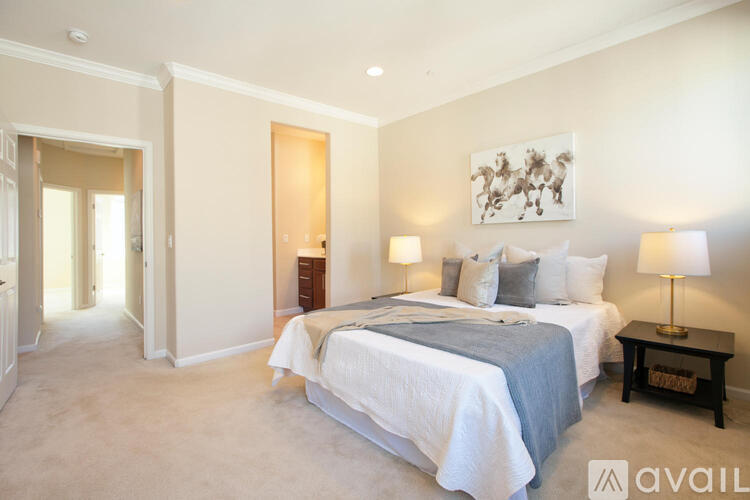A bedroom with two beds and a painting on the wall.