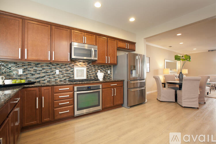 A kitchen with wooden cabinets and a granite countertop.
