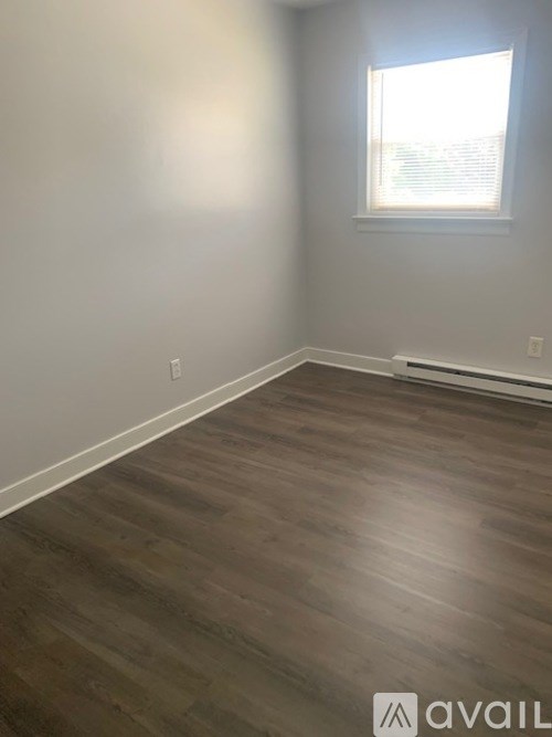 A room with wooden flooring and a window.