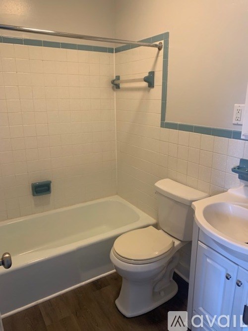 A white toilet sits next to a bathtub in a bathroom.