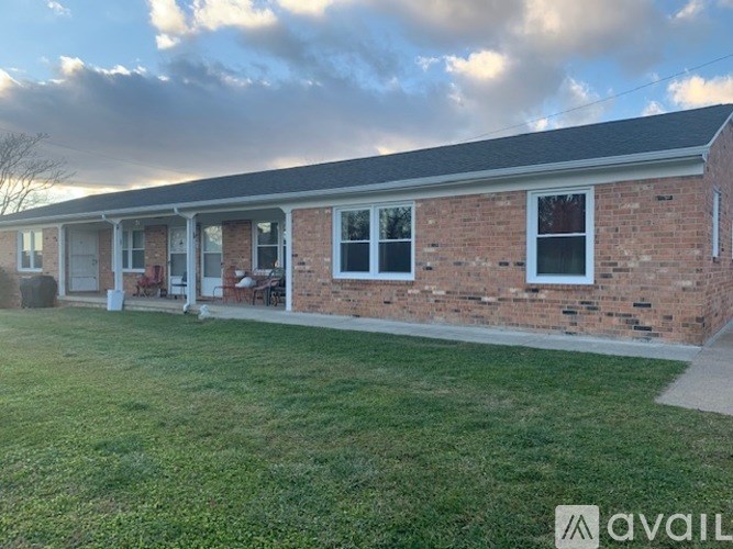 A brick house with a lawn in front.