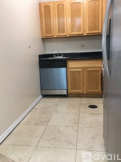 A kitchen with wooden cabinets and a black countertop.