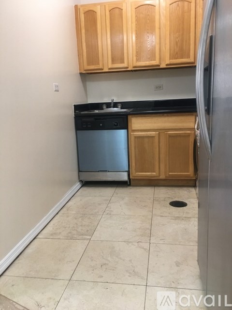 A kitchen with wooden cabinets and a black countertop.