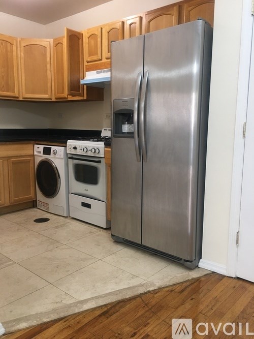 A kitchen with a stainless steel refrigerator and a washer and dryer.