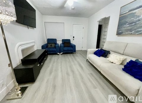 A living room with a white couch and a black entertainment center.