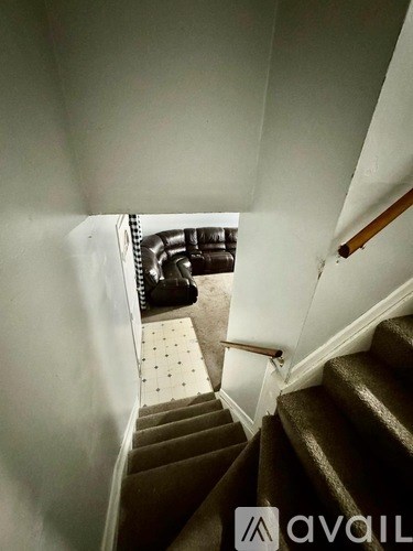 A staircase with a carpeted landing and a wooden handrail.