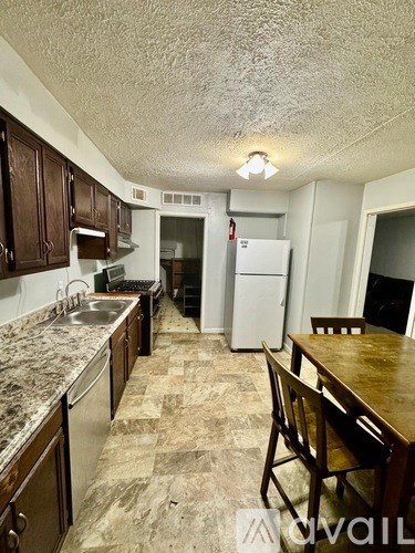 A kitchen with brown cabinets and a marble countertop.