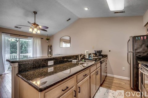 A kitchen with granite countertops and a ceiling fan.