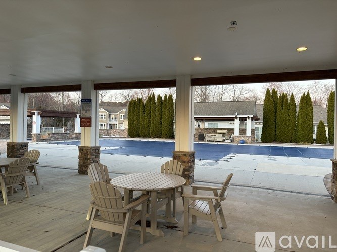 A patio with a table and chairs overlooking a pool.